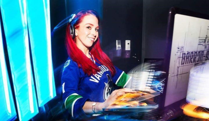 DJ Barron S in her DJ booth wearing a Vancouver Canucks Jersey